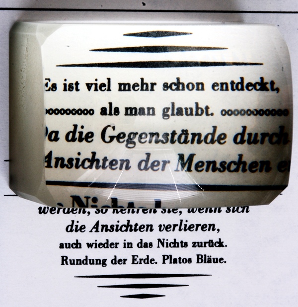 Blick durch einen modernen Lesestein auf einen Text Quelle: Hedwig Storch (CC BY-SA 3.0)